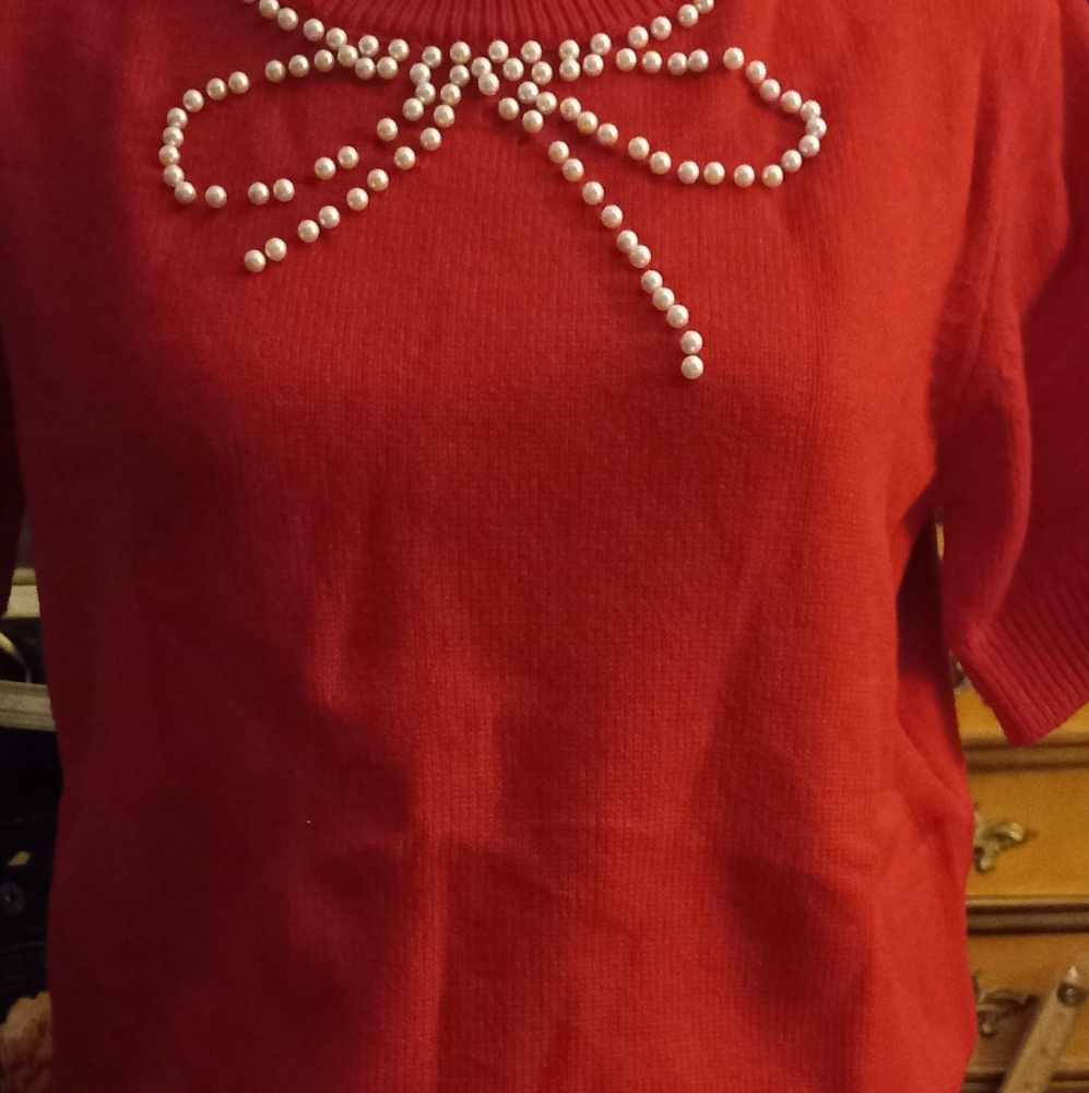 New,elegant red knit sweater with pearl bow  detailing around neckline size med.